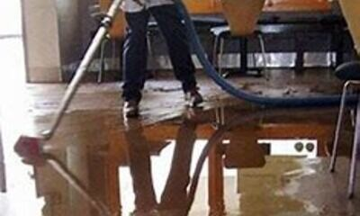 Technician extracting standing water from an indoor floor